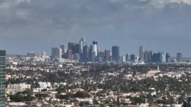 Metropolis 'in havadan yükselen görüntüleri. Kentsel yerleşim yerlerindeki evler ve arka planda şehir merkezindeki gökdelenler. Los Angeles, Kaliforniya, ABD.