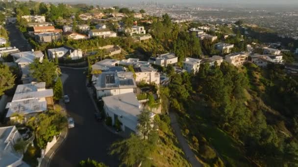 ハリウッドヒルズの住宅の行の高角度ビュー 高層ビルが立ち並ぶ大都市のパノラマの景色を遠くにご覧ください 米国カリフォルニア州ロサンゼルス — ストック動画