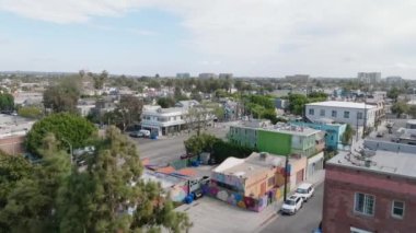 Caddelerin ve şehirlerdeki binaların üzerinden ileriye doğru uçuyor. Palmiye ağaçlarıyla kaplı yollar. Los Angeles, Kaliforniya, ABD.