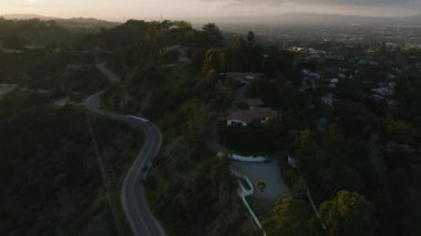 Alacakaranlıkta varoşlardaki tepelerde yol alan araçların yüksek açılı görüntüsü. Los Angeles, Kaliforniya, ABD.