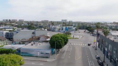 Sokak ve kavşağın üzerinden uçarak yerleşim yerlerinin olduğu mahalleye git. Yollarda trafik az. Los Angeles, Kaliforniya, ABD.