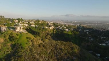Büyük şehrin tepelerindeki lüks yerleşim yerlerinin güzel hava görüntüleri. Uzaktaki modern yüksek ofis binaları ile Metropolis. Los Angeles, Kaliforniya, ABD.