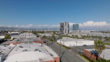 Şehir merkezindeki alçak düz çatılı iş yerlerinin hava görüntüleri. Yoğun yolun yakınındaki modern tasarım ofis binası. Los Angeles, Kaliforniya, ABD.