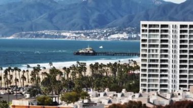 Deniz kıyısının kaydırak ve pan görüntüleri. Santa Monica ilçesindeki kumsaldaki eğlence parkı. Los Angeles, Kaliforniya, ABD.