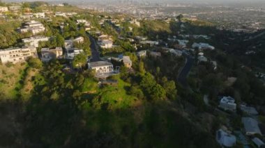 Hollywood Hills 'te altın saatinde büyük konutların ve konutların yüksek açılı manzarası. Şehir manzarasını yukarı kaldır. Los Angeles, Kaliforniya, ABD.
