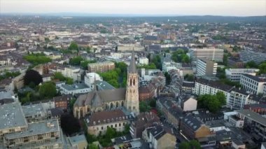 İleri, kasabanın üzerinde kilise kulesinin etrafında uçar. Şehir merkezinin panoramik manzarası. Heilig Kreuz Kirche, Aachen, Almanya.