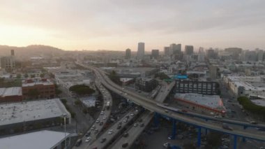 Büyük şehirdeki ulaşım altyapısının havadan görüntüsü. Günbatımına karşı yoğun çoklu şerit ve çok katlı yol kavşağı. San Francisco, California, ABD