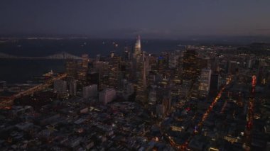 Şehir merkezinde aydınlatılmış akşam panoramik görüntüleri. Transamerica Piramidi, Satış Kulesi ve alacakaranlıkta çevreleyen gökdelenler. San Francisco, California, ABD