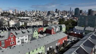 Şehir merkezindeki yerleşim yerlerinin üzerinden uçuyor. Arka plandaki yüksek katlı ofis kuleleri. San Francisco, California, ABD