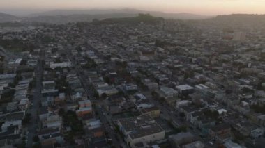 Alacakaranlıkta şehir merkezindeki evlerin üzerinden uçuyor. Kasaba gelişiminin havadan görüntüsü. San Francisco, California, ABD