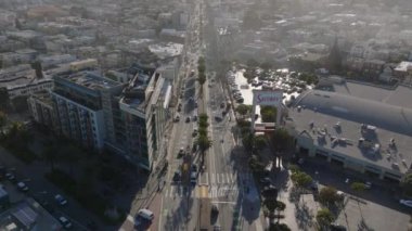 Şehir merkezindeki kalabalık ana caddenin üzerinde ilerliyorlar. Parlak öğleden sonra güneşi. San Francisco, California, ABD