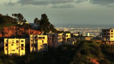 Tepelerdeki sakinler öğleden sonra güneşiyle aydınlanıyor. Şehir merkezindeki gökdelenleri gözler önüne seriyor. Los Angeles, Kaliforniya, ABD.