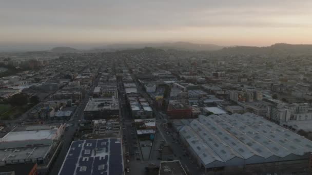 夕暮れ時に街の上を飛ぶ 都市のバラとカラフルな夕日の空の建物のブロックの空中映像 米国カリフォルニア州サンフランシスコ — ストック動画