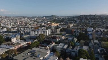 Şehir merkezinin üzerinde büyük şehirler uçuyor. Binalar altın saatinde güneş ışığıyla aydınlanır. San Francisco, California, ABD