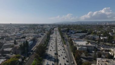 Altın saatinde yoğun trafik varken önemli caddelerin üzerinde ilerliyorlar. Kentsel çevreye ait hava görüntüleri. Los Angeles, Kaliforniya, ABD.