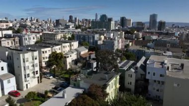 Güneşli bir günde şehrin üzerinde ilerliyorlar. Modern yüksek katlı ofis ve uzaktaki apartmanlar. San Francisco, California, ABD