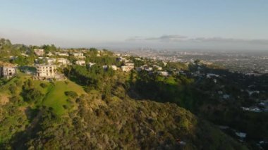 Büyük şehrin tepelerindeki lüks yerleşim yerlerinin güzel hava görüntüleri. Uzaktaki modern yüksek ofis binaları ile Metropolis. Los Angeles, Kaliforniya, ABD.