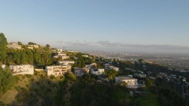 Metropolis 'in tepelerindeki zengin kentsel yerleşim yerlerinin üzerinden uç. Şehir merkezindeki gökdelenlerden oluşan bir grup. Los Angeles, Kaliforniya, ABD.