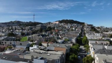 Şehir merkezindeki yerleşim yerlerinde alçak uçuş. Tepeler ve telekomünikasyon kulesi mavi gökyüzüne karşı. San Francisco, California, ABD