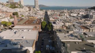 Şehir merkezindeki caddenin üzerinde ilerliyorlar. Su yüzeyi uzakta. San Francisco, California, ABD.