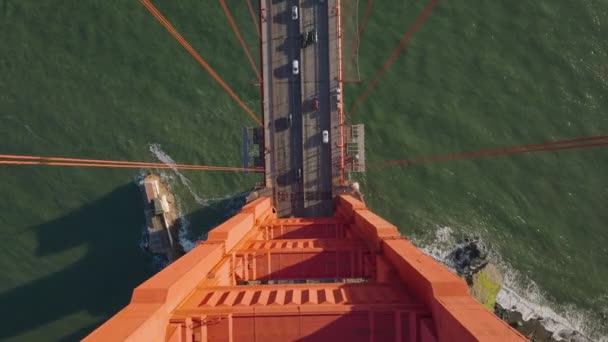 从上至下拍摄的大型悬索桥塔下车辆行驶的镜头 黄金时代著名的红色金门大桥 美国加利福尼亚州旧金山 — 图库视频影像