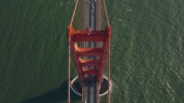 Görkemli köprü kulesinin yüksek açılı görüntüsü, köprüyü su üzerinde taşıyan ipleri destekleyen devasa çelik yapı. Golden Gate Köprüsü 'ndeki çok şeritli yolda trafik var. San Francisco, California, ABD.