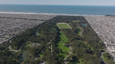 Golden Gate Parkı 'ndaki yeşilliğin havadan panoramik görüntüsü ve Pasifik Okyanusu kıyısındaki yerleşim bölgelerindeki yoğun şehir gelişimi. San Francisco, California, ABD.