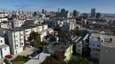 Güneşli bir günde şehrin üzerinde ilerliyorlar. Modern yüksek katlı ofis ve uzaktaki apartmanlar. San Francisco, California, ABD