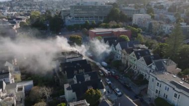 Yanan evde profesyonel itfaiyecilerin müdahalesiyle uçmak. Altın Saatteki Kentsel Konut Bölgesi 'nin hava manzarası. San Francisco, California, ABD