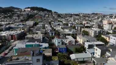 Şehir merkezindeki evlerin üzerinden ileriye doğru uçuyor. Şehirdeki caddeler boyunca çeşitli binalar. San Francisco, California, ABD
