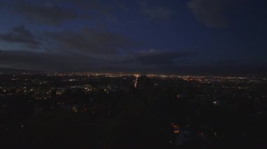 Büyük şehrin hava panoramik gece görüntüleri. Aydınlanmış sokaklar ve binalar, gün batımından sonra gökyüzünde bulutlar. Los Angeles, Kaliforniya, ABD.