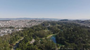 Golden Gate Parkı 'nın yerleşim yerleriyle çevrili havadan yükselen görüntüleri. Şehrin panoramik manzarası ve şehir merkezindeki gökdelenler. San Francisco, California, ABD.