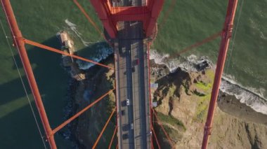 Golden Gate Köprüsü 'nün altındaki sahilin yüksek açılı görüntüsü. Büyük asma köprünün heybetli kulesinin çelik inşaatının üzerinden uç. San Francisco, California, ABD.