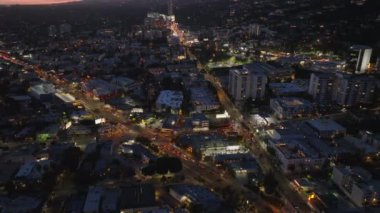 Şehirdeki trafik ve kavşaklardaki hava indirme görüntüleri. Yukarı doğru eğik, renkli alacakaranlık gökyüzünü göster. Los Angeles, Kaliforniya, ABD