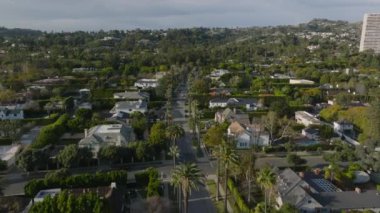 Evleri, bahçeleri ve ağaçları olan lüks yerleşim yerlerinin üzerinde uçuyorlar. Los Angeles, Kaliforniya, ABD