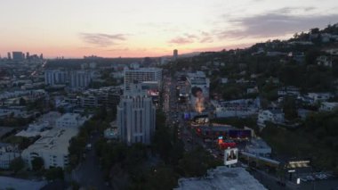 Gökyüzünün rengarenk alacakaranlık ışıklarına karşı gökyüzü manzarası ve şehirdeki büyük reklamlar. Sunset Bulvarı 'nda yoğun trafik var. Los Angeles, Kaliforniya, ABD