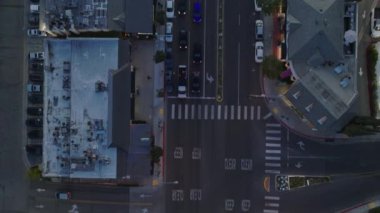 Alacakaranlıkta şehrin caddelerinde kavşağın ve trafiğin en alt görüntüsü. Trafik ışıklarında duran araçlar. Los Angeles, Kaliforniya, ABD