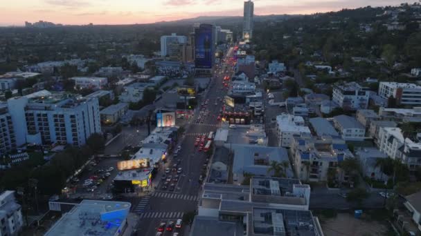 大規模な広告に囲まれた賑やかな通りの上を飛ぶ 夕暮れ時の広い大通り 米国カリフォルニア州ロサンゼルス — ストック動画
