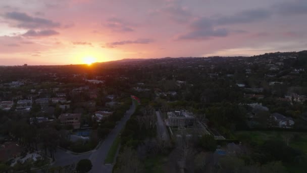 夕方に都市部の建物の上を飛ぶ ロマンチックな夕日と雲とカラフルな空 米国カリフォルニア州ロサンゼルス — ストック動画