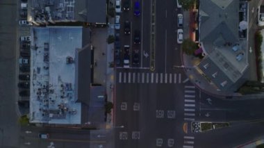 Alacakaranlıkta şehrin caddelerinde kavşağın ve trafiğin en alt görüntüsü. Trafik ışıklarında duran araçlar. Los Angeles, Kaliforniya, ABD