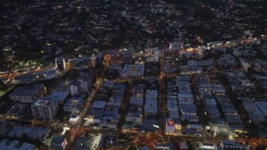 Gece şehrindeki binaların yüksek açılı manzarası. Sokaklarda normal evlerin üzerinden uç. Los Angeles, Kaliforniya, ABD