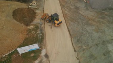 Yükleyicinin yüksek açılı görüntüsü kazılmış materyalleri taşırken ve yığının üzerine atarken. Frankfurt am Main, Almanya.