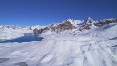 Gökyüzü kuşları Himalayalar 'ın yüksek rakımlarında güzel mavi Tilicho gölünün manzaralı manzarasını seyreder. Tilicho Gölü patikası, Nepal.