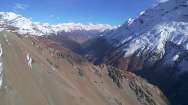 Nepal 'deki hava yükselen Himalaya Dağları manzarası nefes kesici. Karlı tepeler, desenler, desenler ve yazın açık mavi gökyüzü manzarası. Tilicho ana kampına giden yol..