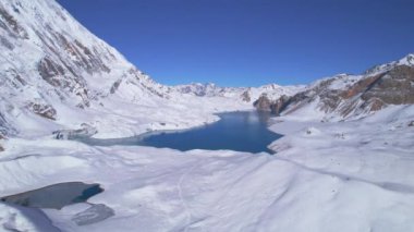 Gökyüzü kuşları Himalaya dağlarının yüksek rakımlı güzel mavi Tilicho gölünün manzarasını görüyorlar. Tilicho Gölü yürüyüş rotası, Manang, Nepal.