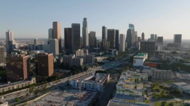 Altın saatinde şehir merkezinin üzerinden uç. Şehir merkezindeki gökdelenlerin gökyüzü manzarası. Los Angeles, Kaliforniya, ABD.