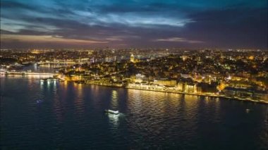 Aydınlanmış binaların ve sokakların üzerinden uç. Galata Kulesi Müzesi geceye doğru parlıyor. Metropolis 'in akşam hiperhız çekimi. İstanbul, Türkiye.