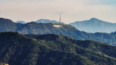 Yeşil tepelerin havadan inen manzara görüntüleri. Radyo vericisi ve ünlü Hollywood tabelası. Los Angeles, Kaliforniya, ABD.