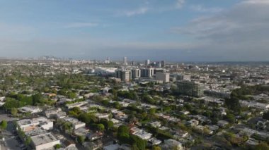 Şehir merkezindeki evlerin üzerinden uçuyor. Metropolis 'in panoramik manzarası ve şehir merkezindeki gökdelenler. Los Angeles, Kaliforniya, ABD