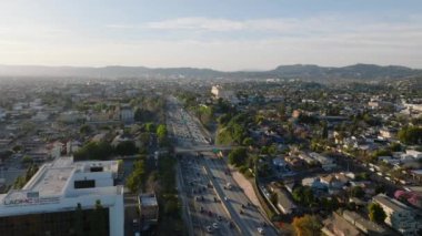 Kentsel yerleşim bölgelerinden geçen kalabalık çoklu şeritli otoyolun havadan görünüşü. Los Angeles, Kaliforniya, ABD.